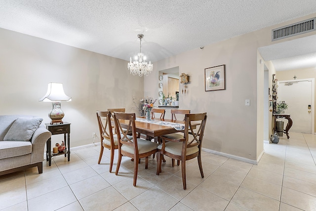 dining area featuring light tile patterned floors, a chandelier, and a textured ceiling