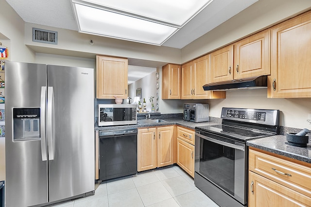 kitchen featuring light tile patterned floors, stainless steel appliances, light brown cabinetry, and sink