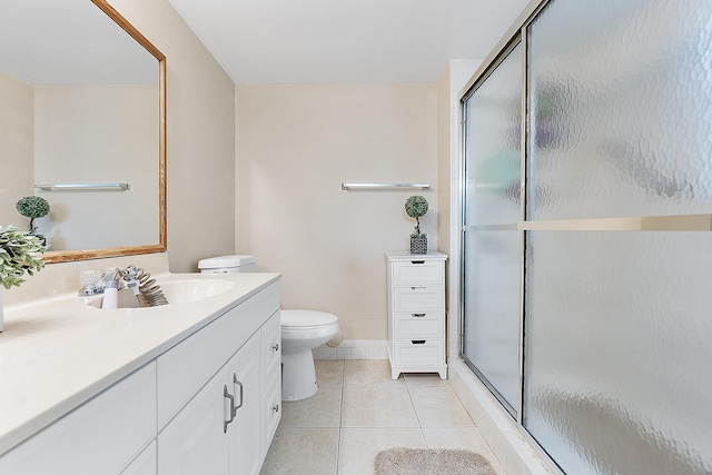 bathroom with tile patterned floors, toilet, vanity, and walk in shower