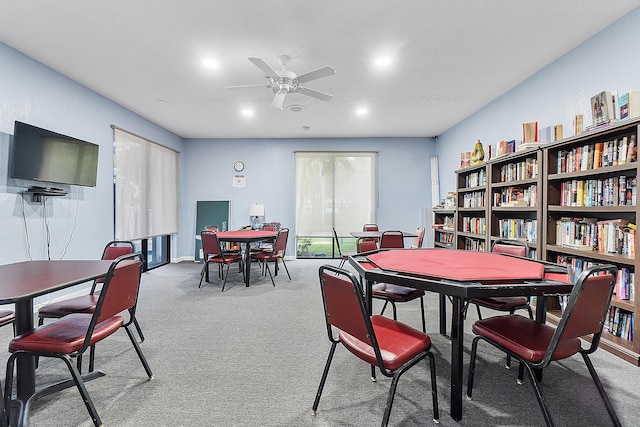 carpeted dining room with ceiling fan