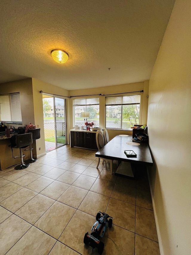 tiled dining area featuring a textured ceiling