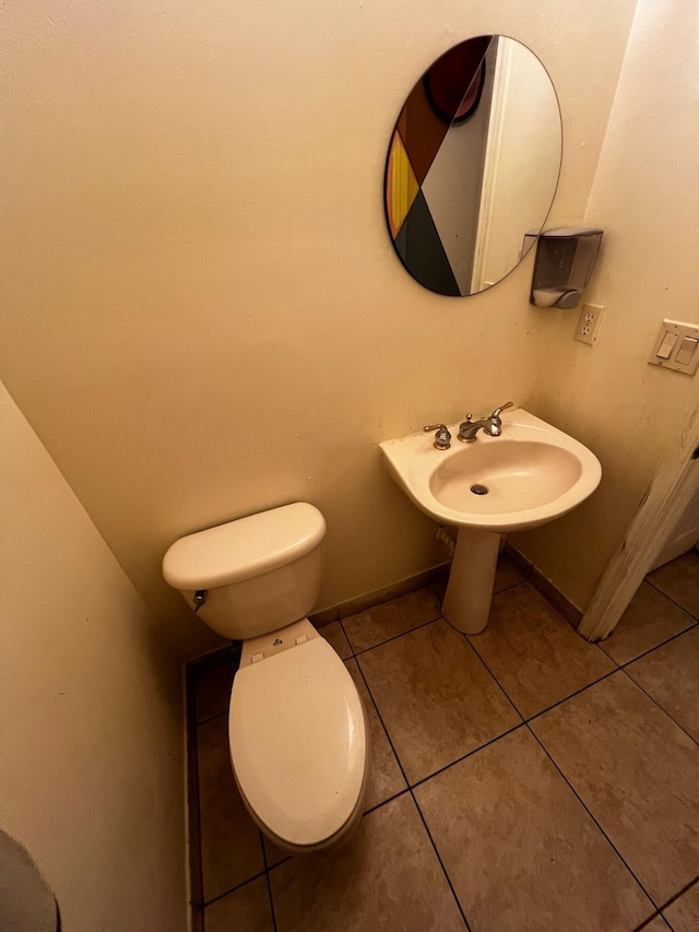 bathroom featuring toilet, tile patterned floors, and sink