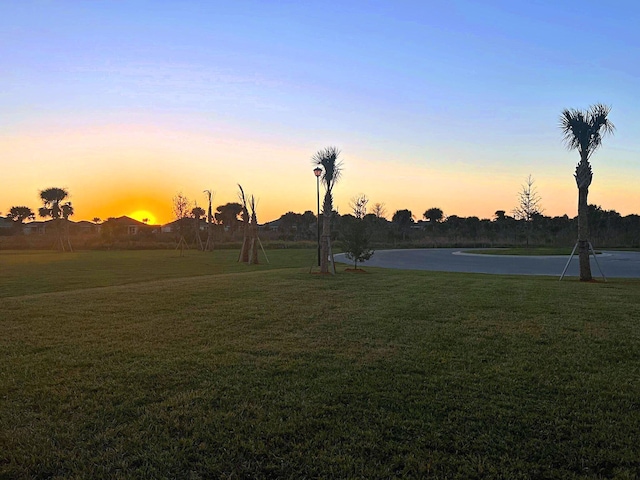 yard at dusk featuring a water view