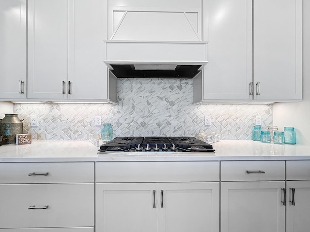 kitchen with premium range hood, decorative backsplash, and white cabinets