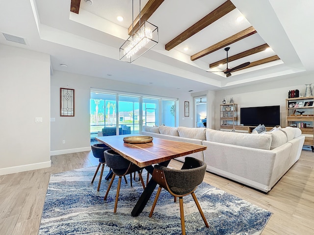 dining room with a tray ceiling, beamed ceiling, ceiling fan, and light wood-type flooring