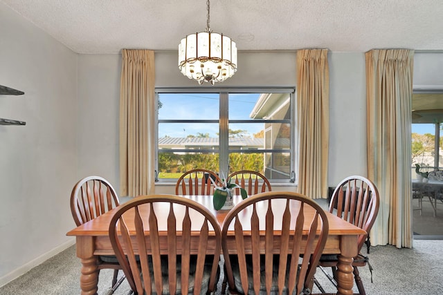 dining room featuring carpet, a notable chandelier, and a textured ceiling