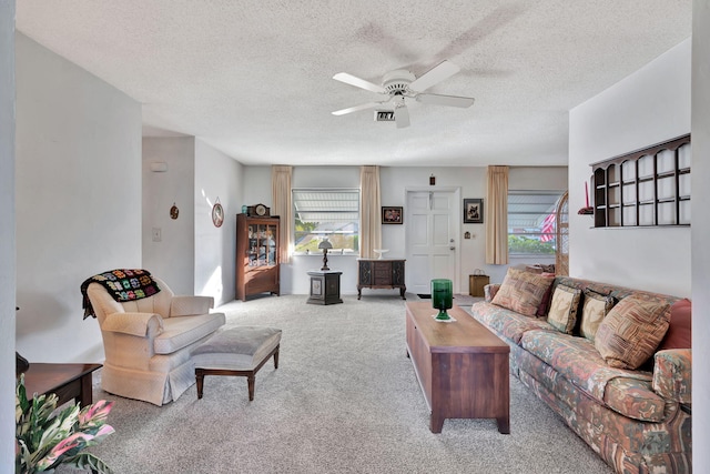 carpeted living room featuring a textured ceiling and ceiling fan