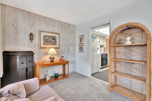 carpeted living room with wooden walls