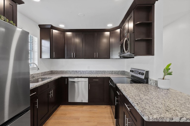 kitchen with sink, dark brown cabinetry, light stone countertops, and appliances with stainless steel finishes