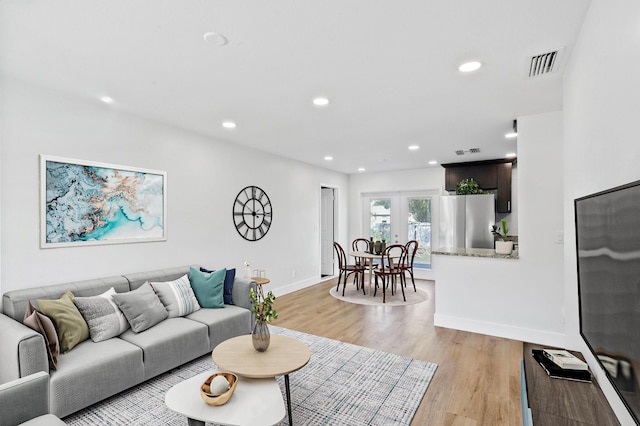 living room with light wood-type flooring and french doors