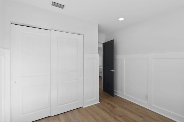 unfurnished bedroom with light wood-type flooring and a closet