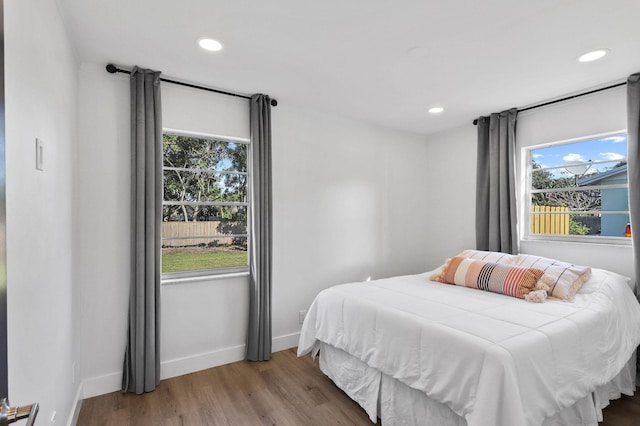 bedroom with wood-type flooring and multiple windows