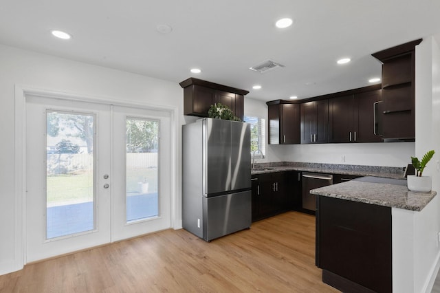 kitchen featuring stainless steel appliances, french doors, dark brown cabinetry, and light hardwood / wood-style flooring