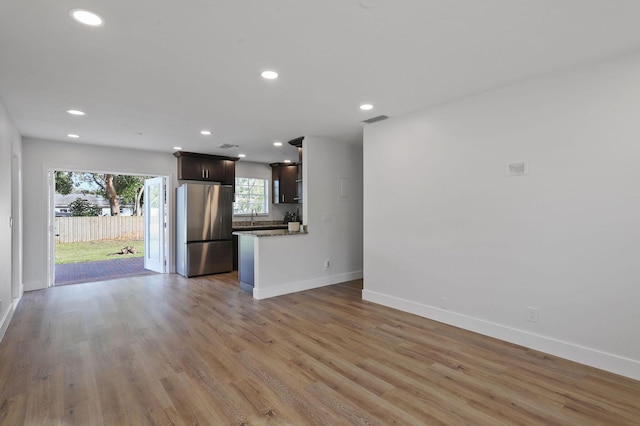 unfurnished living room featuring light wood-type flooring and sink