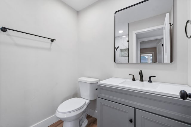 bathroom featuring toilet, hardwood / wood-style flooring, and vanity