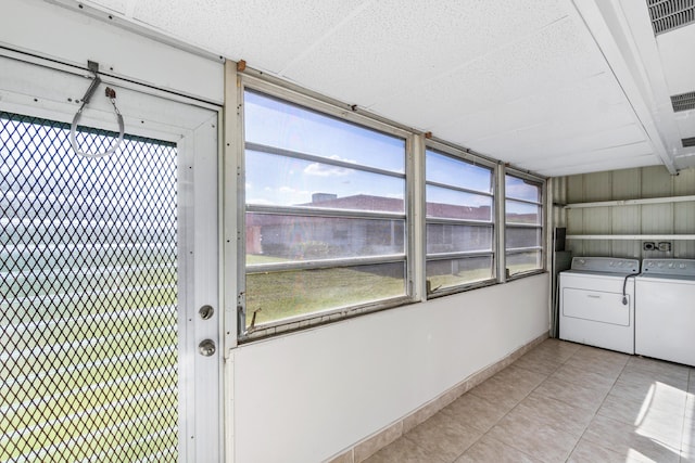 clothes washing area featuring light tile patterned flooring and independent washer and dryer