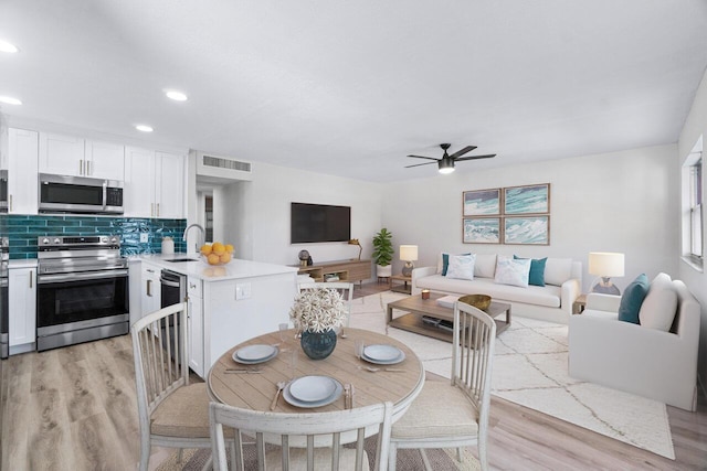 dining space featuring sink, ceiling fan, and light hardwood / wood-style flooring