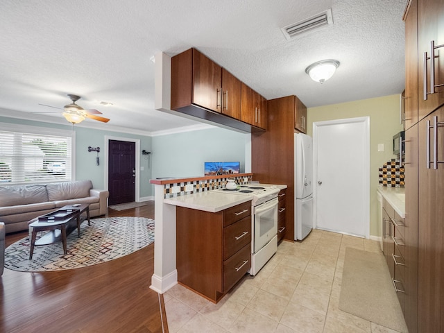 kitchen featuring ceiling fan, crown molding, a textured ceiling, white appliances, and light tile patterned floors