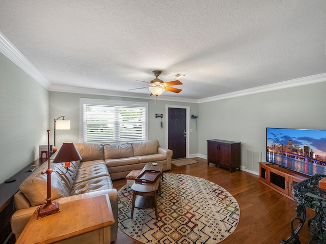 living room featuring crown molding, dark hardwood / wood-style flooring, ceiling fan, and a textured ceiling