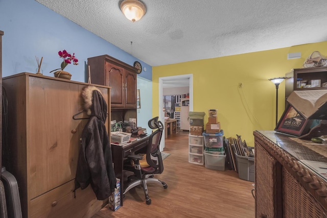 home office featuring light hardwood / wood-style floors and a textured ceiling