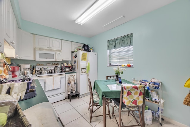 kitchen with light tile patterned floors, white cabinets, and white appliances