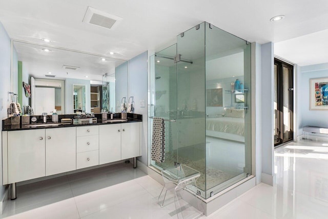 bathroom with a shower with shower door, tile patterned floors, and vanity