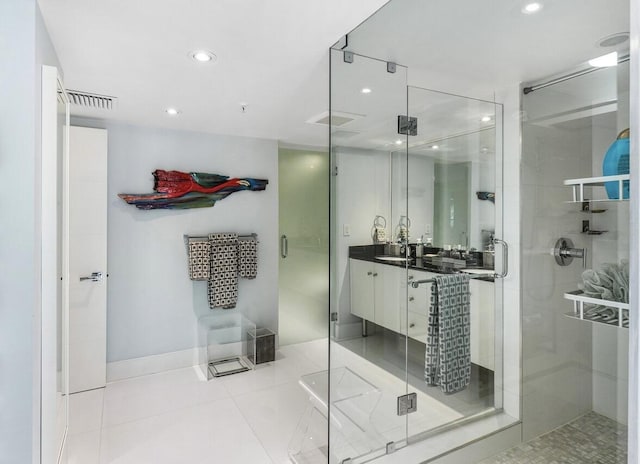 bathroom with tile patterned flooring, a shower with shower door, and vanity