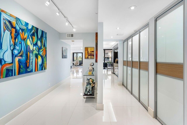 hallway with light tile patterned floors and rail lighting