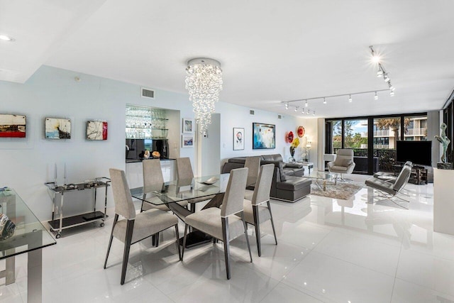 tiled dining space featuring a wall of windows and a notable chandelier