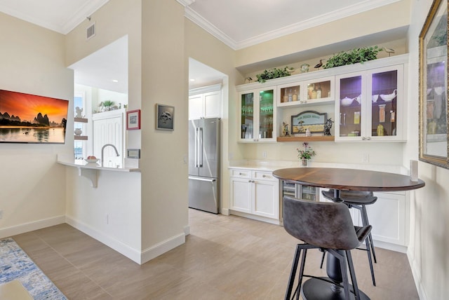 kitchen with white cabinetry, high end fridge, and crown molding