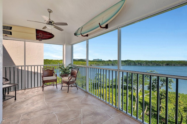 sunroom featuring ceiling fan, a water view, and a healthy amount of sunlight