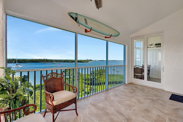 sunroom featuring a water view and vaulted ceiling