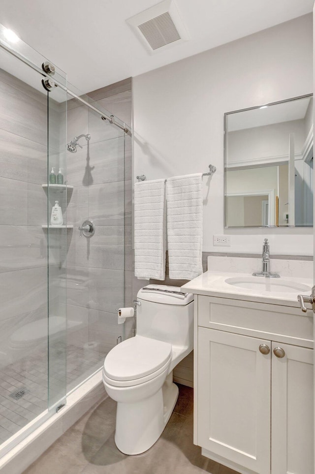 bathroom with walk in shower, vanity, and toilet