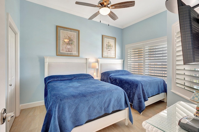 bedroom featuring ceiling fan, ornamental molding, and light wood-type flooring