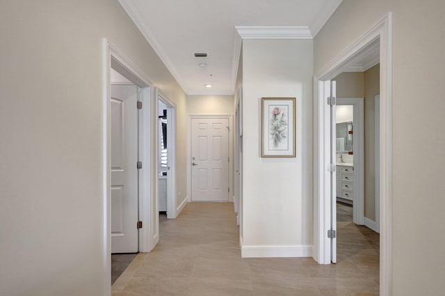 corridor featuring light tile patterned floors and ornamental molding