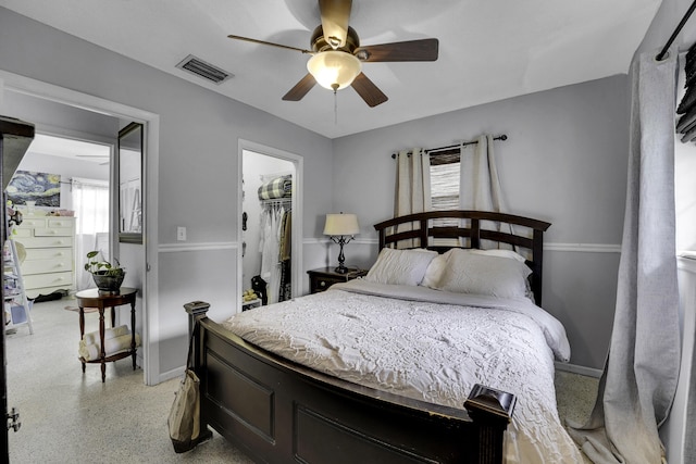 bedroom featuring ceiling fan and a walk in closet