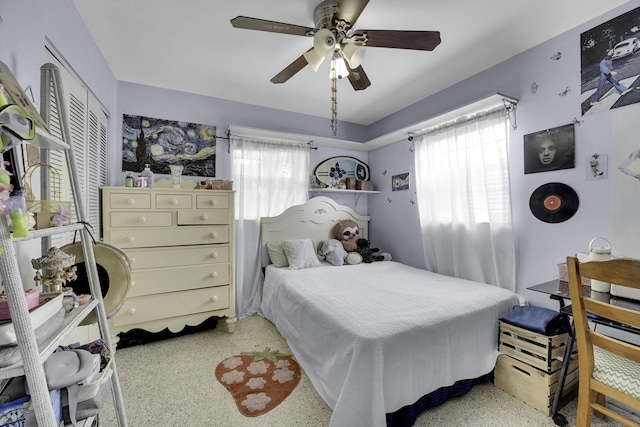 bedroom featuring multiple windows, ceiling fan, and a closet