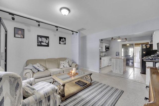 living room with light tile patterned floors, track lighting, and ceiling fan