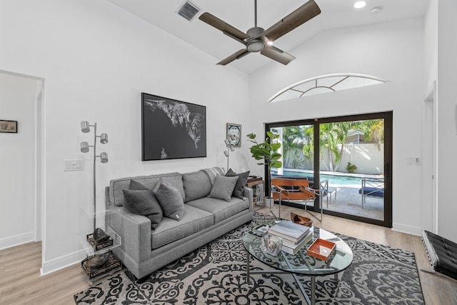 living room featuring ceiling fan, high vaulted ceiling, and light hardwood / wood-style floors