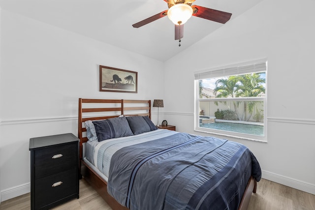 bedroom with ceiling fan, light hardwood / wood-style flooring, and lofted ceiling