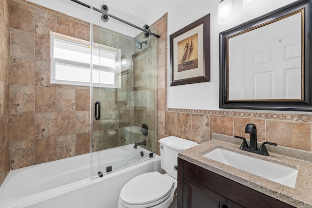 full bathroom featuring vanity, backsplash, combined bath / shower with glass door, toilet, and tile walls