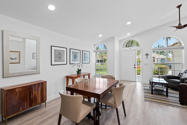 dining area with ceiling fan, vaulted ceiling, radiator, and light hardwood / wood-style flooring