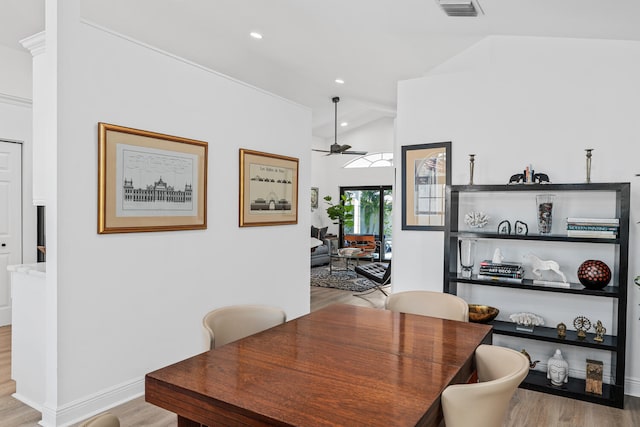 dining room featuring ceiling fan, light hardwood / wood-style floors, and vaulted ceiling