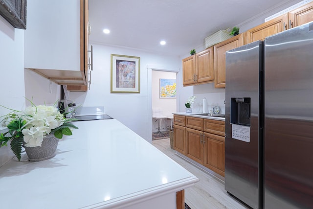 kitchen with black electric cooktop, stainless steel fridge, crown molding, and light hardwood / wood-style floors