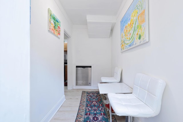 sitting room with crown molding and light wood-type flooring