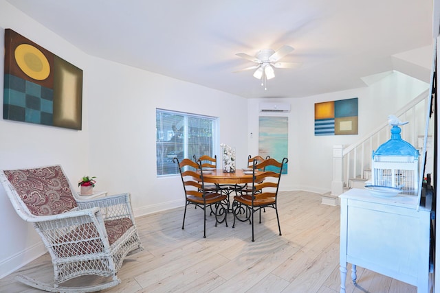 dining room with an AC wall unit, ceiling fan, and light hardwood / wood-style flooring