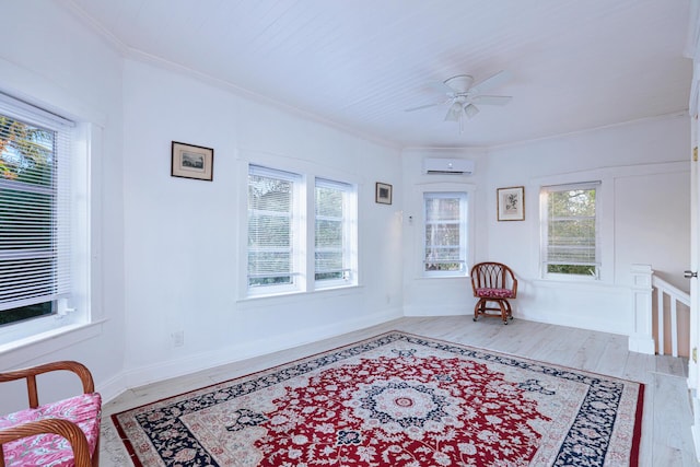 living area featuring ceiling fan, crown molding, a wall unit AC, and light hardwood / wood-style flooring