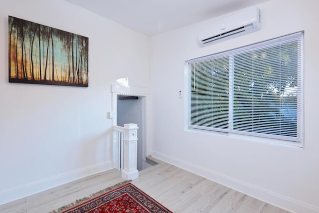 interior space with a wall unit AC and light hardwood / wood-style flooring