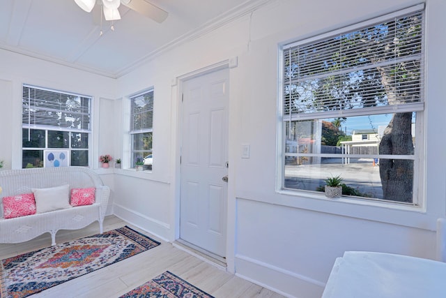 interior space featuring wood-type flooring, ceiling fan, and crown molding