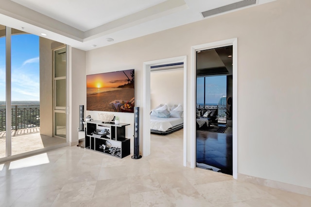 hallway featuring a raised ceiling and a wall of windows